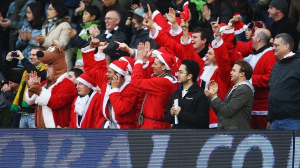 Adeptos da Premier League a assistir a um jogo do Boxing Day vestidos de Pais natal