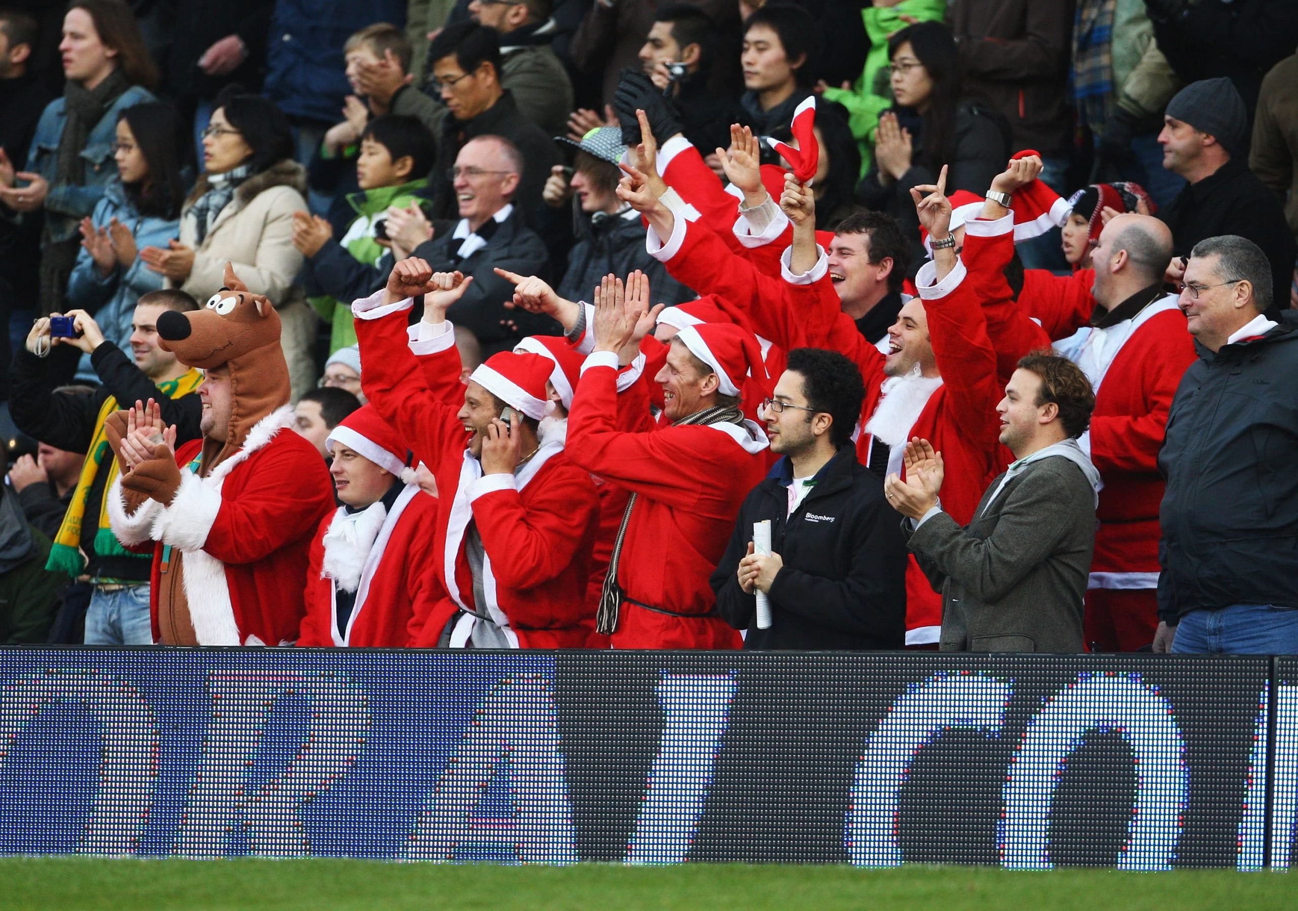 Adeptos da Premier League a assistir a um jogo do Boxing Day vestidos de Pais natal